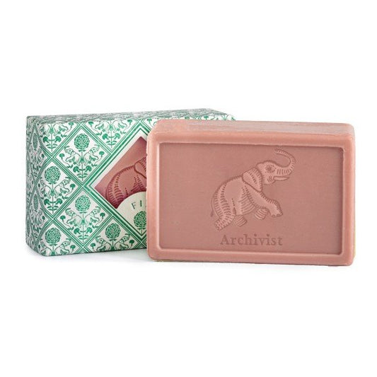 Luxury Fig Hand & Body Soap - L'éléphant opened up and sat on a table next to a wrapped up soap.