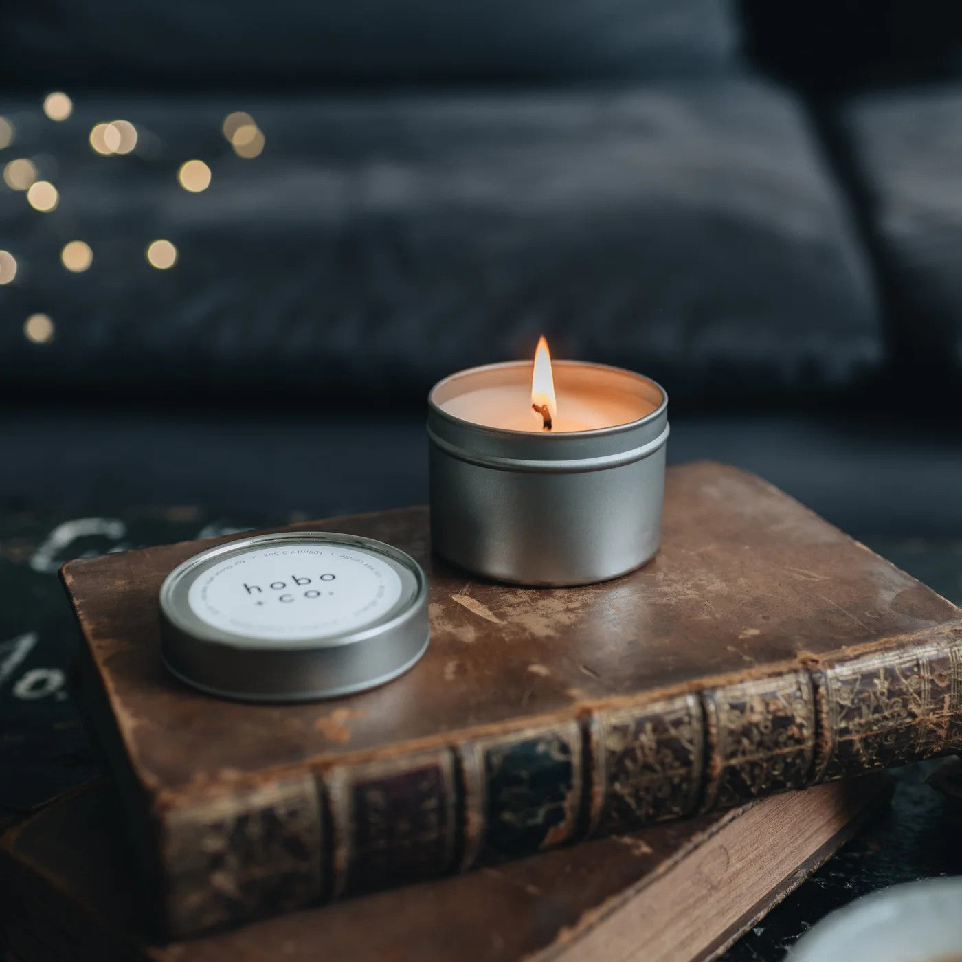 Hobo + co. oawood & tobacco natural soy wax candle stood on a book
