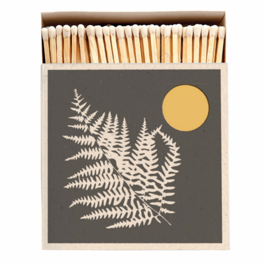 White tipped wooden safety matches popping out of the fern and sun match box